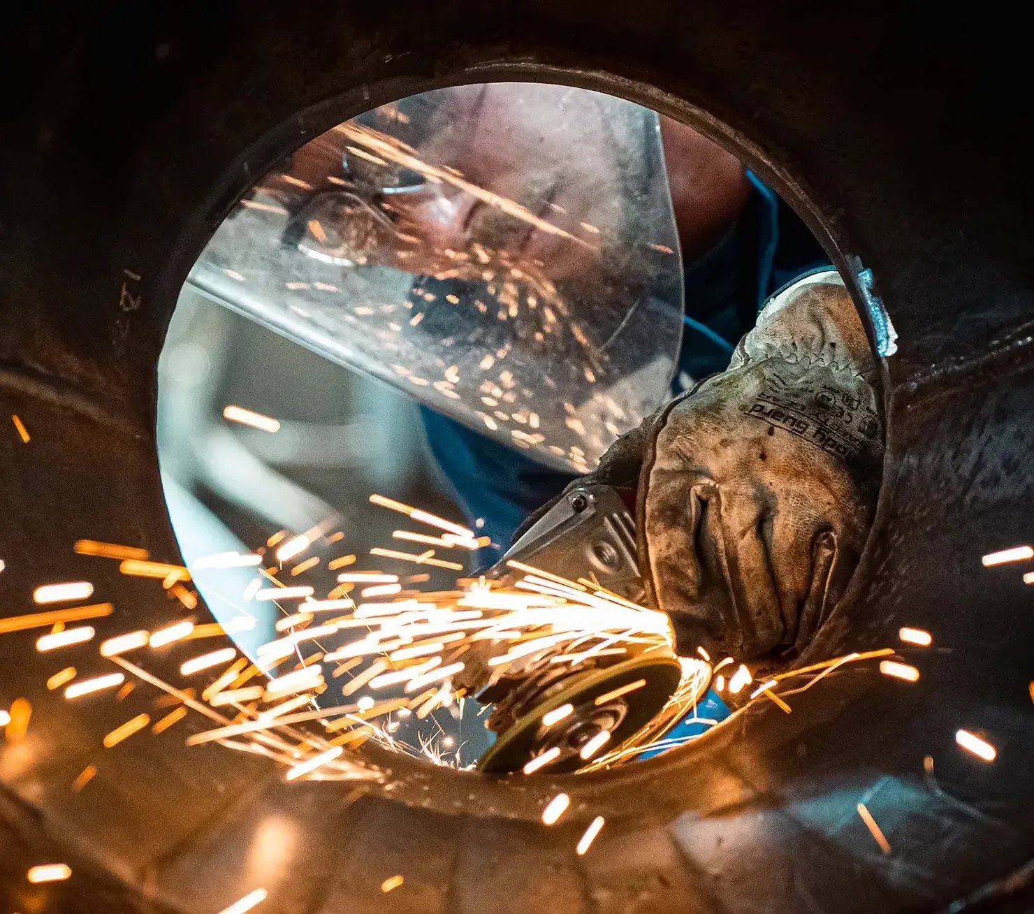 worker-grinding-metal-pipe-with-sparks-1