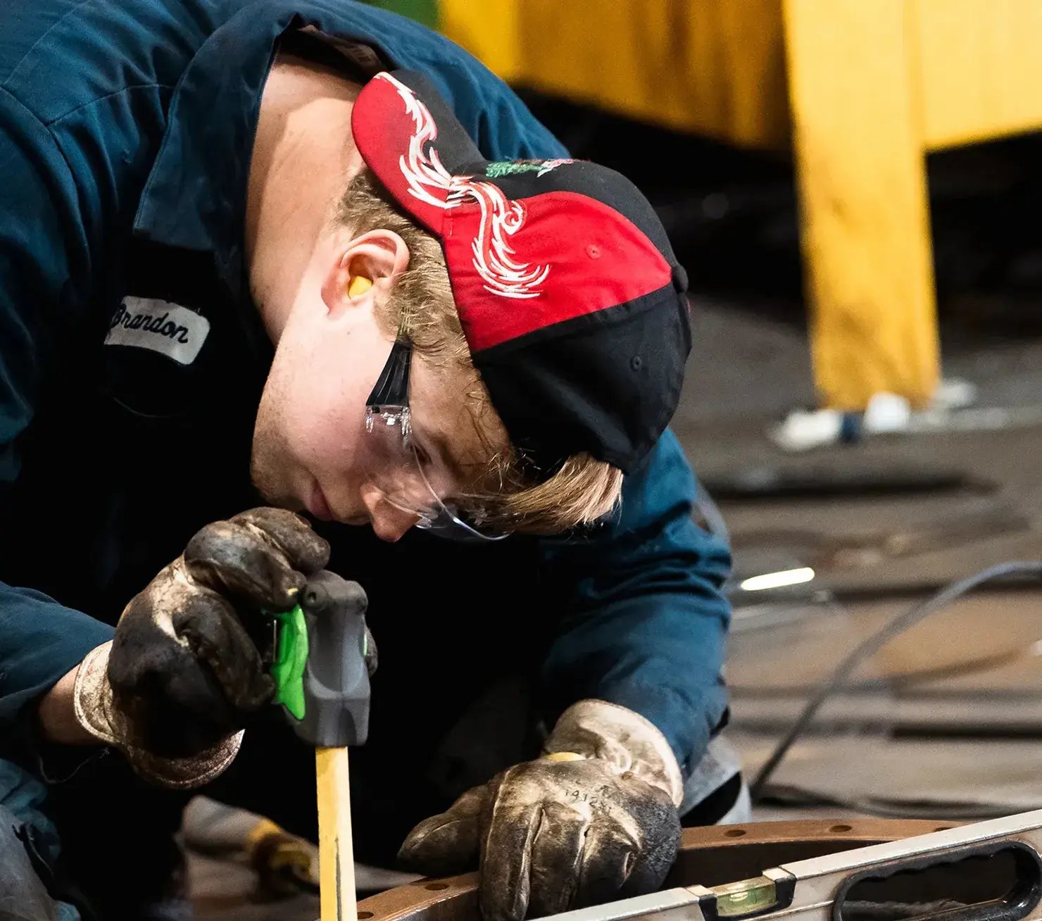 worker-using-spirit-level-on-metal-part-in-workshop