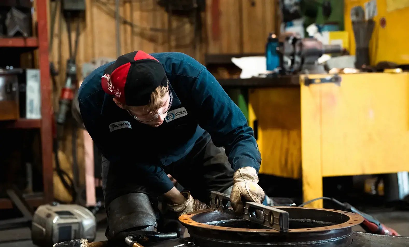 worker-using-level-on-metal-part-in-workshop